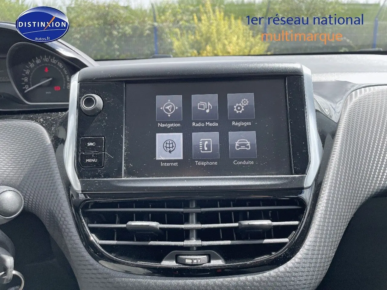 Vue rapprochée de l’écran tactile central et des aérateurs du tableau de bord gris du Peugeot 2008 noir métal de 2016.