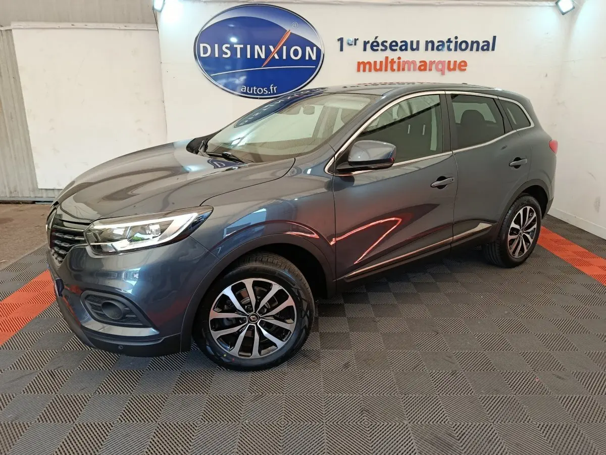 Renault Kadjar Business gris foncé vu en 3/4 avant droit avec jantes alliage et feux LED dans un showroom.