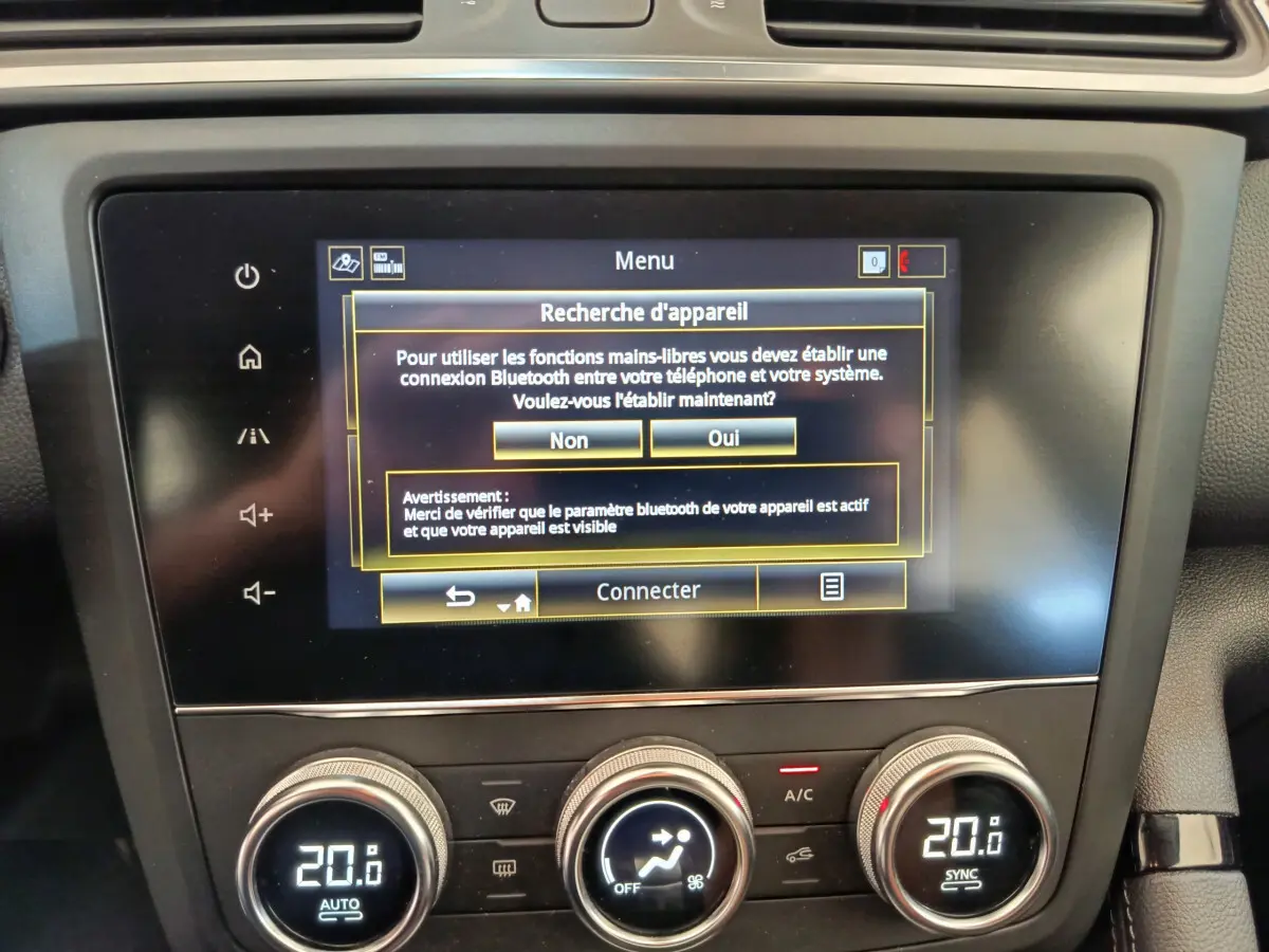 Écran tactile central affichant la recherche Bluetooth et commandes climatisation digitale dans un Renault Kadjar Business gris foncé.
