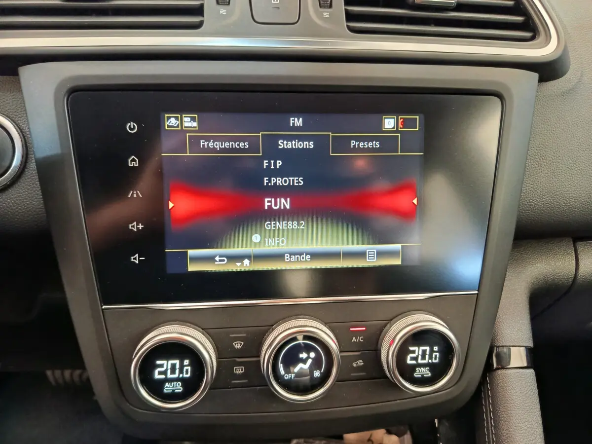 Écran tactile central et commandes climatisation affichant 20°C dans l'habitacle d'un Renault Kadjar gris foncé 2022.