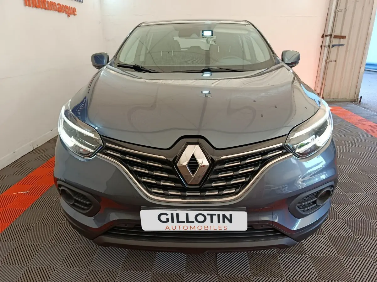 Vue frontale d'un Renault Kadjar Business gris foncé avec phares LED allumés et calandre chromée.