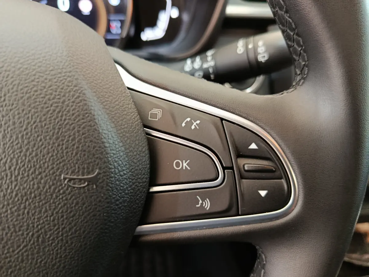 Gros plan sur les commandes multifonctions du volant noir du Renault Kadjar Business 2022, boutons de navigation et appel.