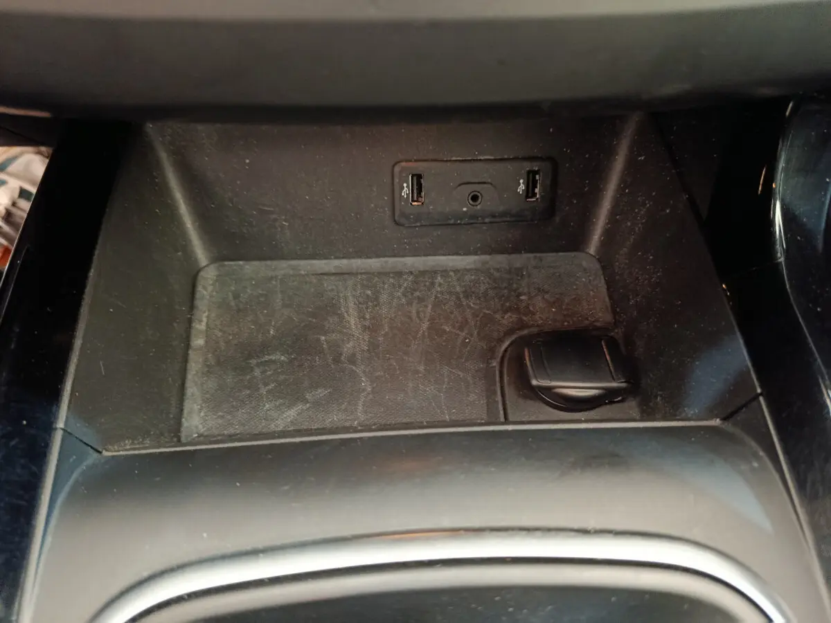 Prise USB double et prise 12V noire dans l'espace de rangement central d'un Renault Kadjar gris foncé 2022.