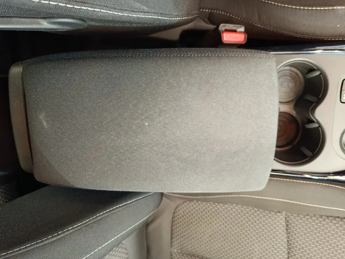 Gros plan sur l'accoudoir central et porte-gobelets du Renault Kadjar Business gris foncé, intérieur tissu noir.