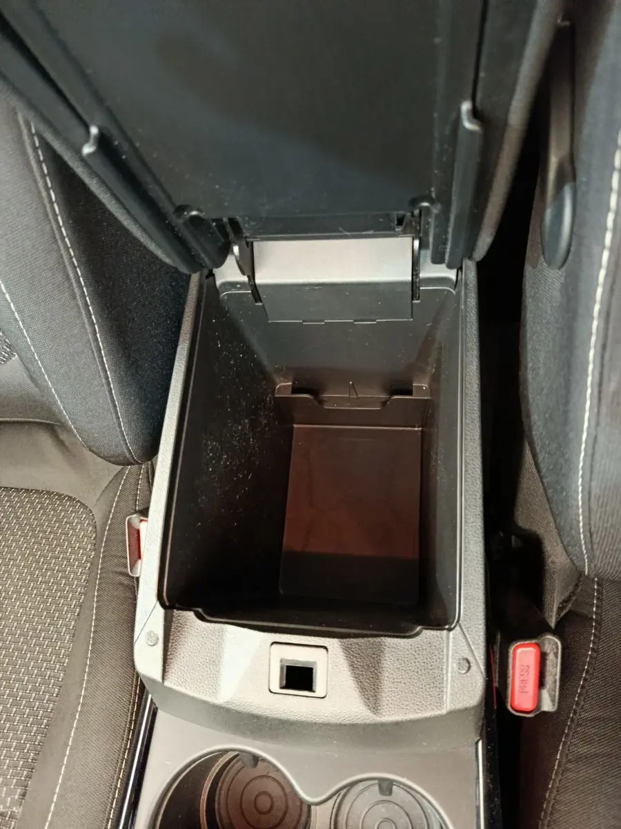 Vue plongeante sur le rangement central ouvert entre les sièges avant du Renault Kadjar Business gris foncé de 2022.