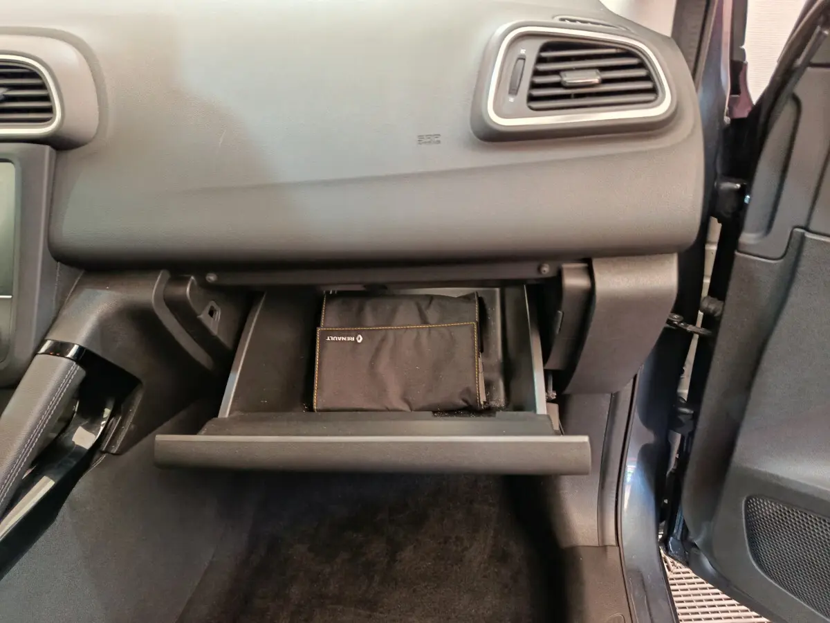 Gros plan sur la boîte à gants ouverte du Renault Kadjar gris foncé Business Blue dCi 115 EDC 2022 avec pochette Renault visible.