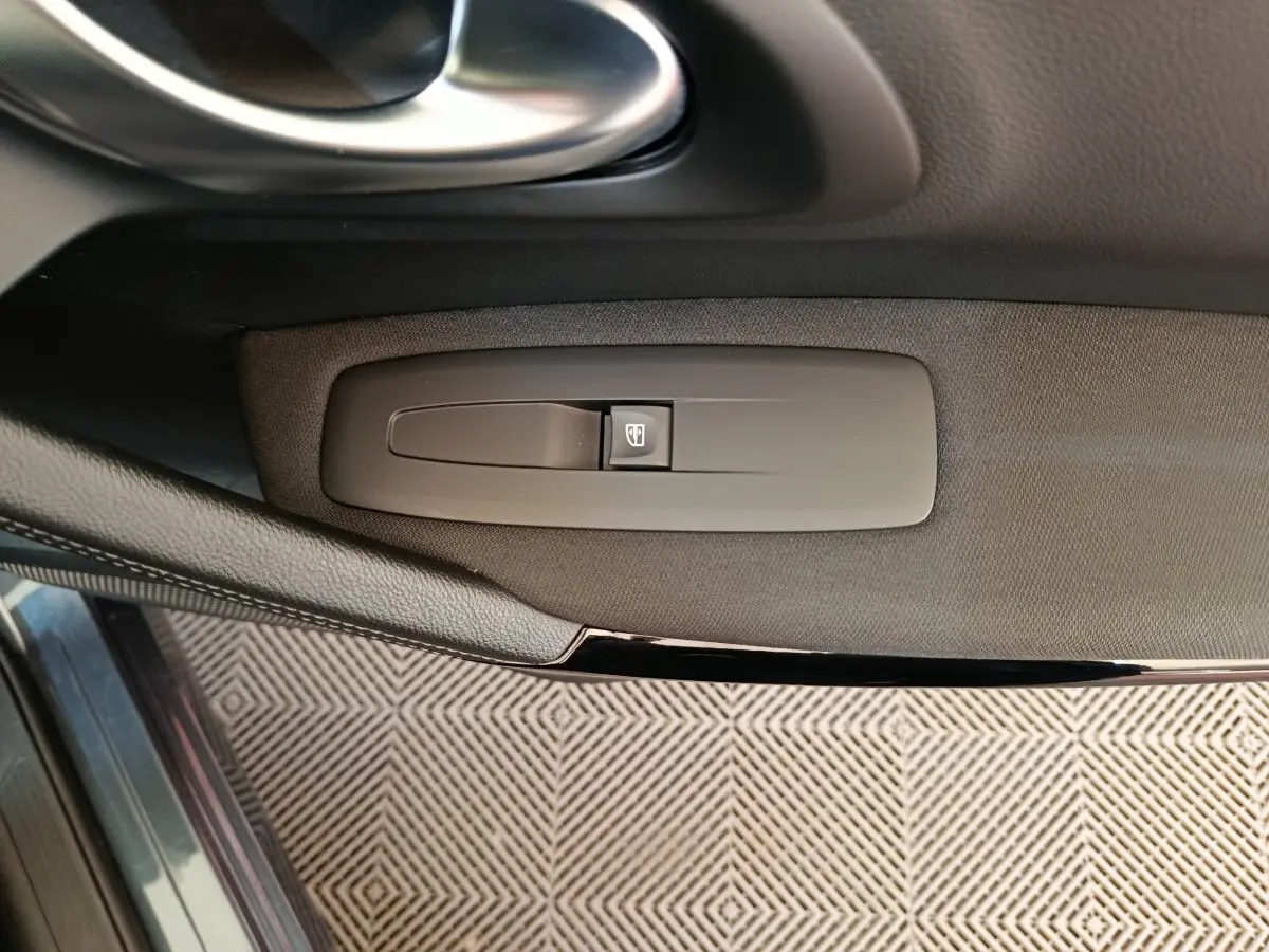 Détail de la commande de lève-vitre sur la porte côté conducteur du Renault Kadjar gris foncé 2022.