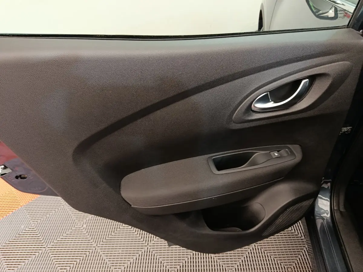 Vue rapprochée de la porte avant droite gris foncé du Renault Kadjar Business 2022 avec poignée intérieure chromée.