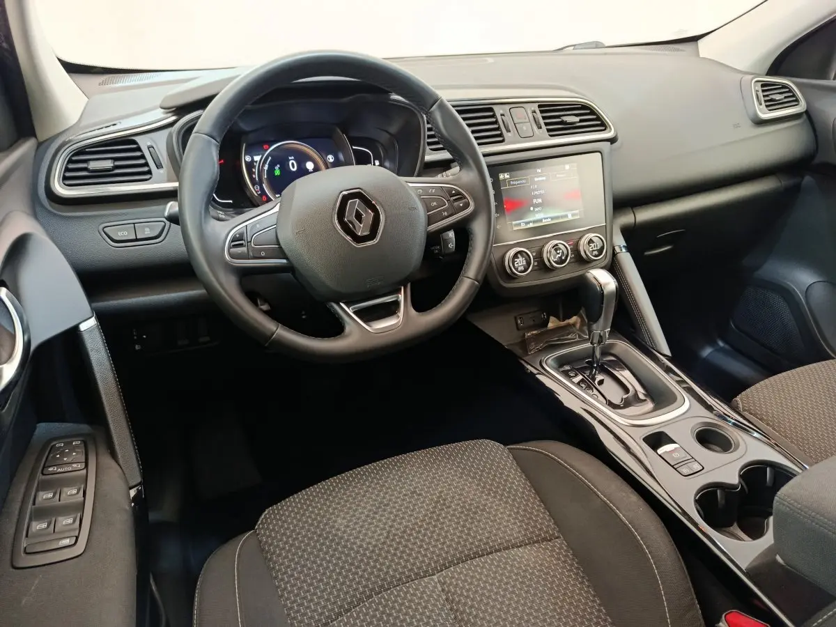 Vue intérieure avant du Renault Kadjar Business gris foncé, tableau de bord avec écran tactile et volant multifonctions.