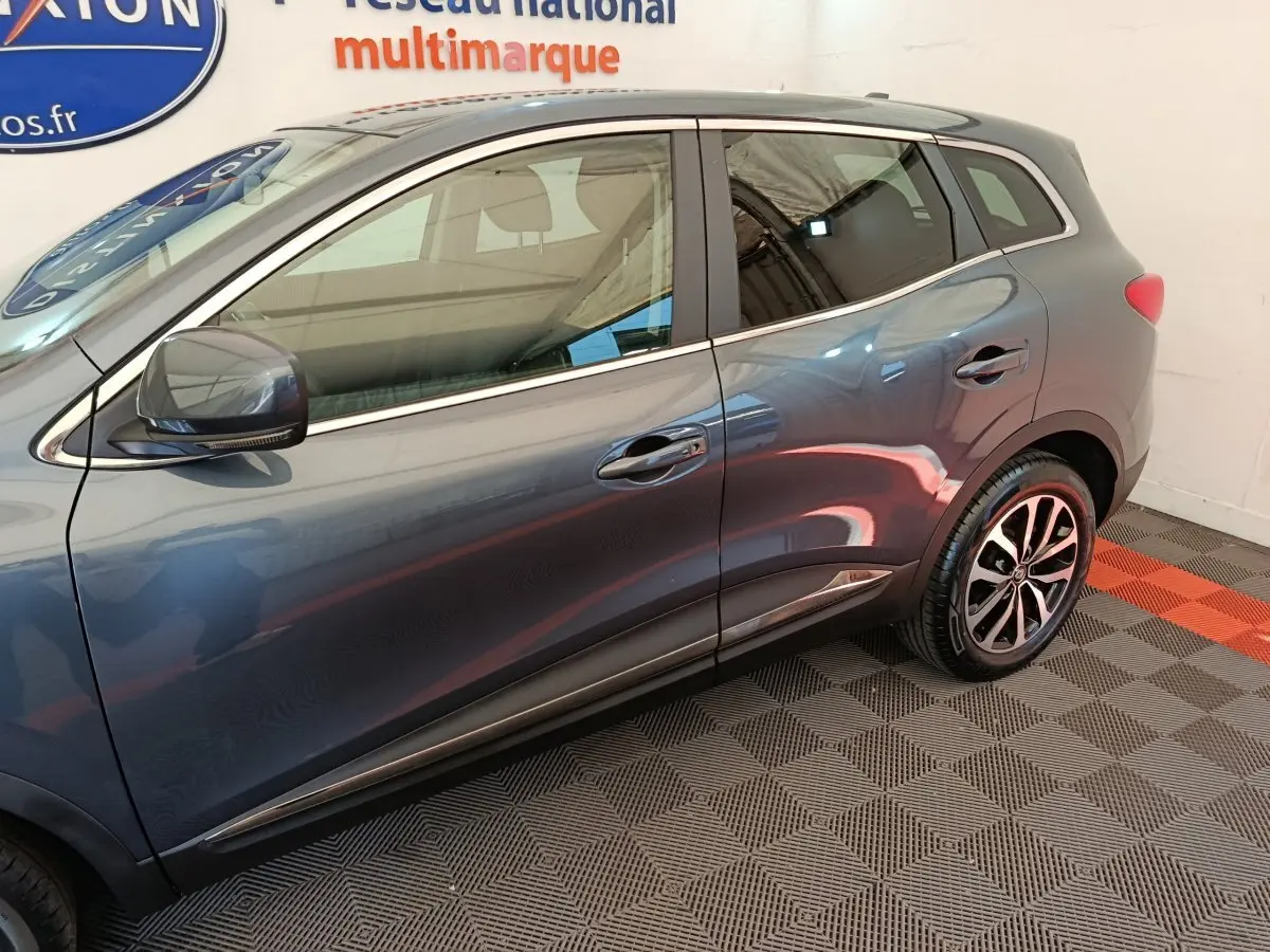 Profil côté gauche du Renault Kadjar gris foncé 2022 avec jantes alliage et rétroviseur électrique.