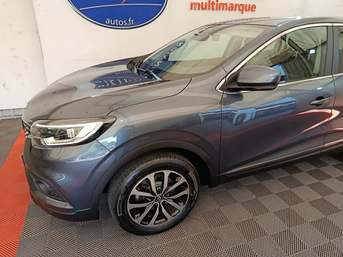 Vue 3/4 avant droit d'un Renault Kadjar Business gris foncé, mettant en valeur ses phares LED et jantes alliage.