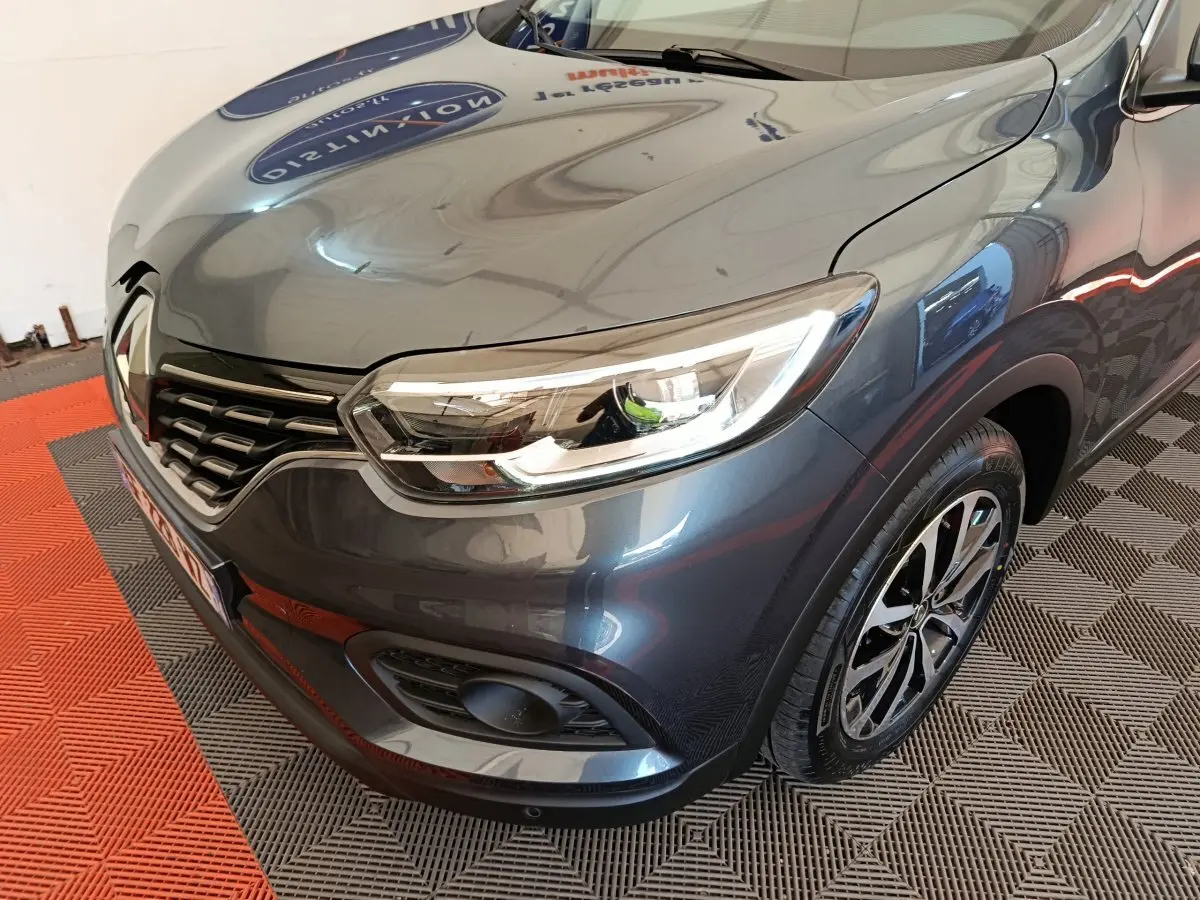 Vue 3/4 avant droit d'un Renault Kadjar Business gris foncé avec phares LED et jantes alliage distinctives.