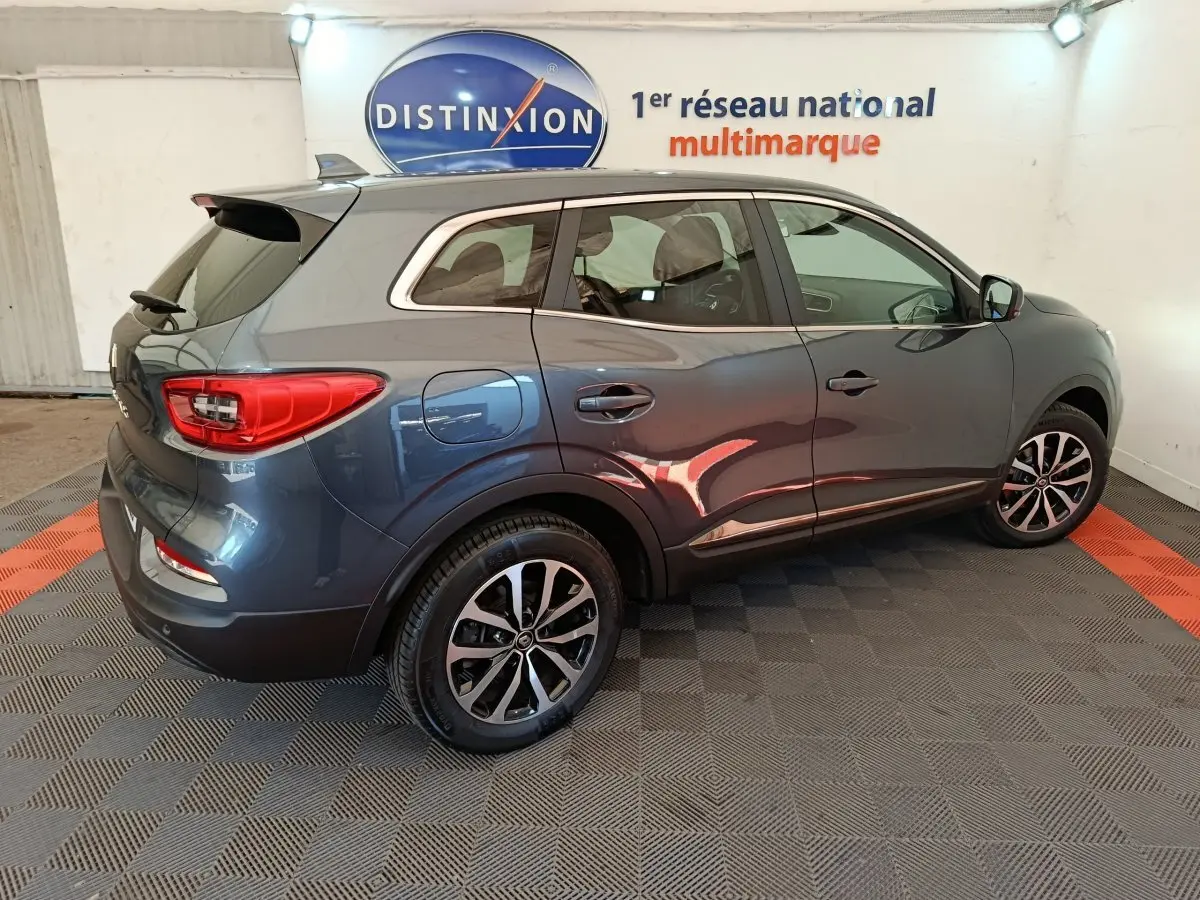 Renault Kadjar Business gris foncé vu de profil droit en intérieur avec jantes alliage et logo Distinxion en arrière-plan.