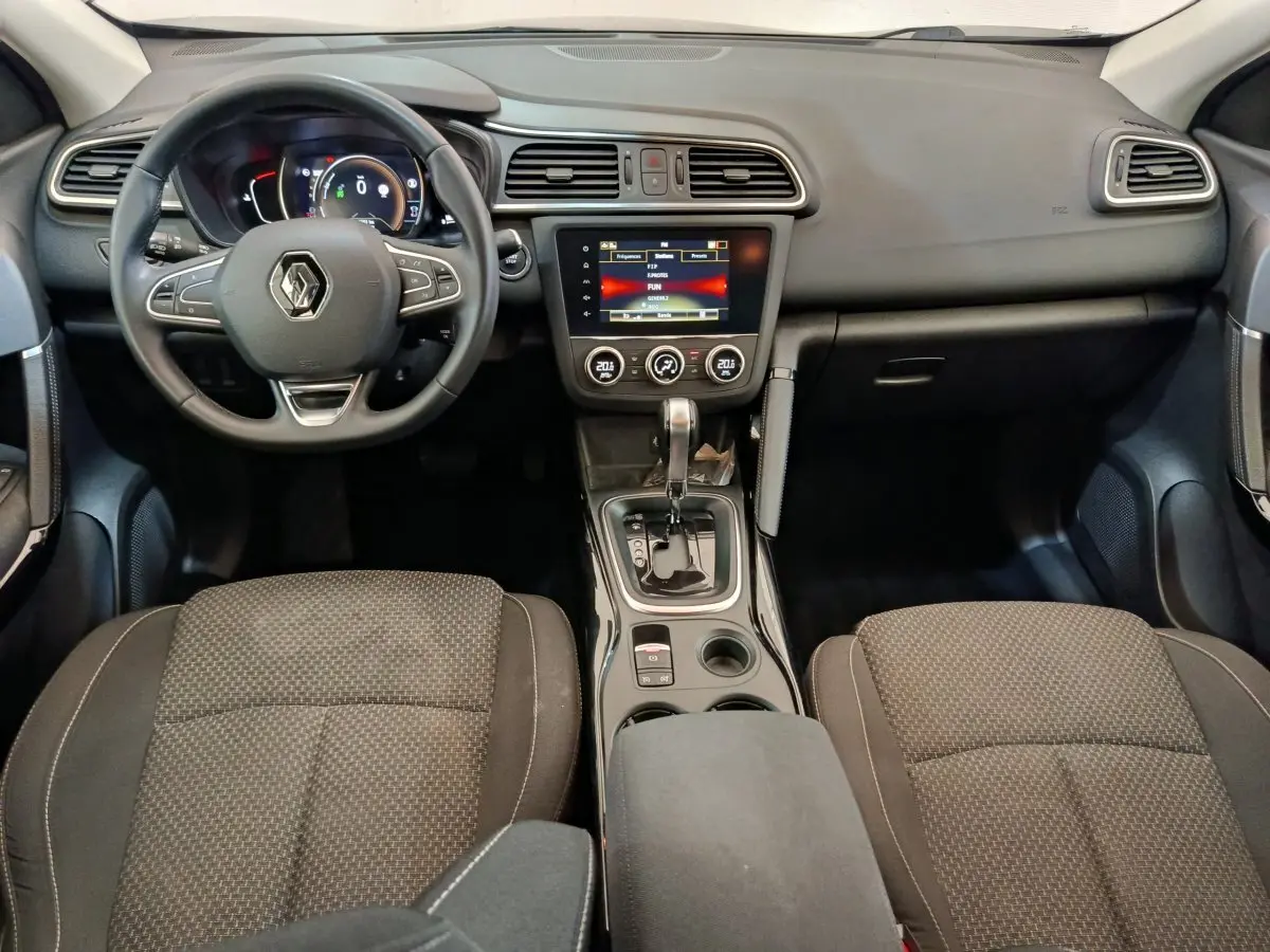 Vue intérieure avant du Renault Kadjar Business 2022, tableau de bord noir avec écran tactile et volant multifonctions.