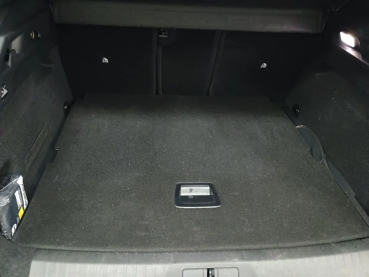 Vue intérieure du coffre du Peugeot 3008 Hybrid 145 Allure, plancher modulable et revêtement noir.