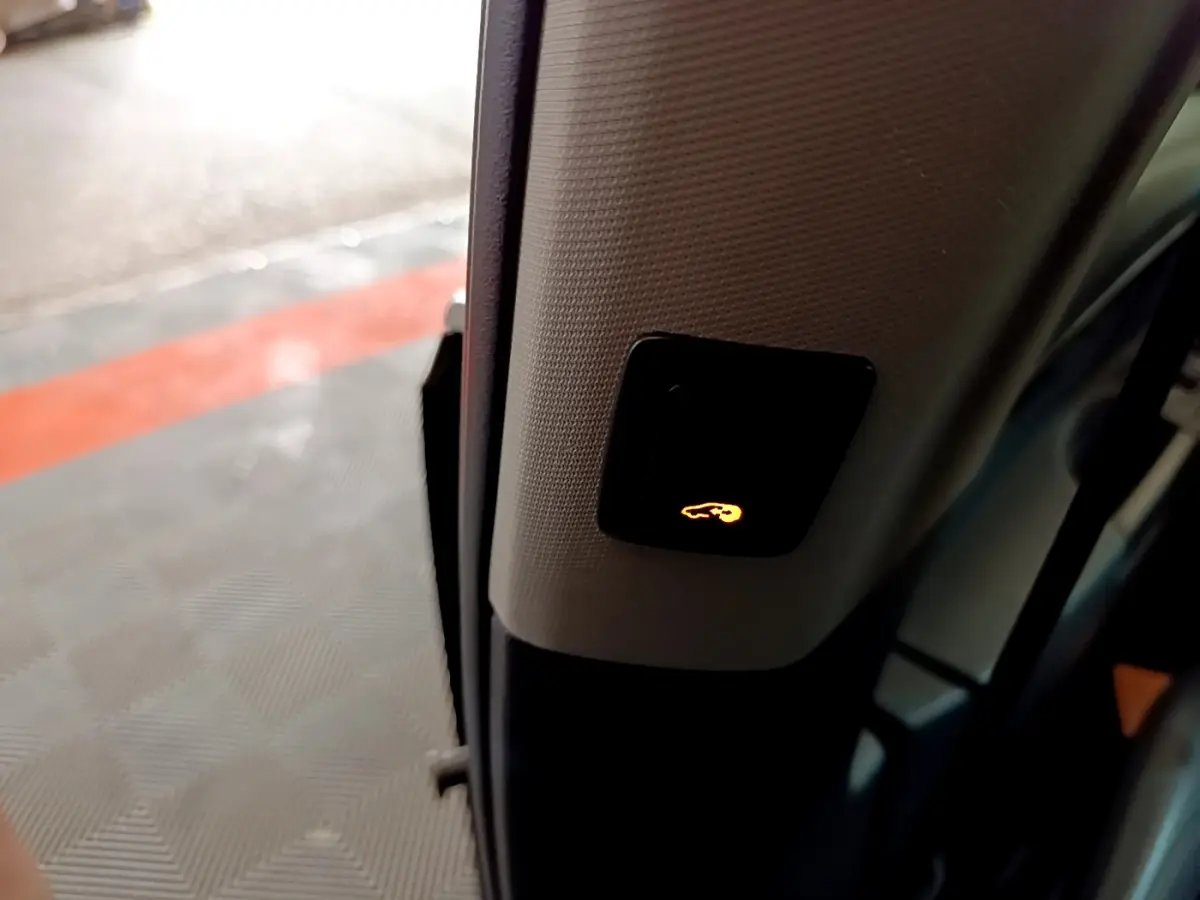 Bouton d'ouverture électrique du hayon éclairé sur le montant intérieur d'une Volkswagen Sharan marron 2017.