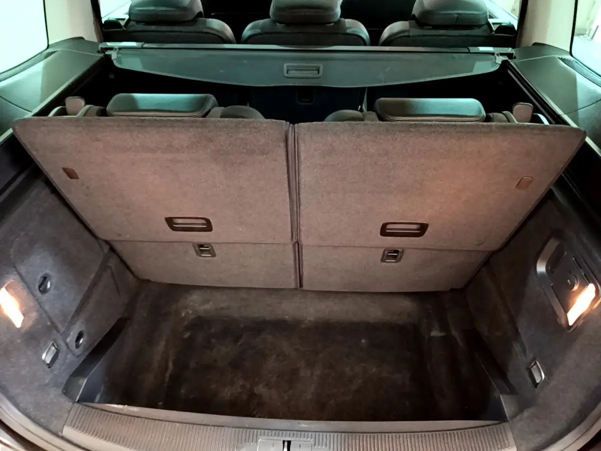 Vue intérieure du coffre arrière du Volkswagen Sharan marron 2017 avec sièges arrière relevés et plancher plat.