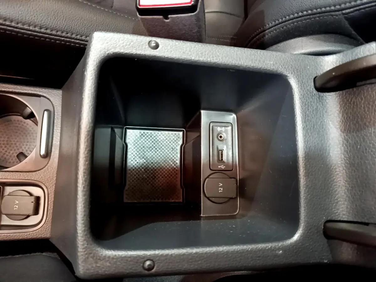 Vue rapprochée de la console centrale intérieure noire du Volkswagen Sharan 2017 avec prises USB, jack et 12V.