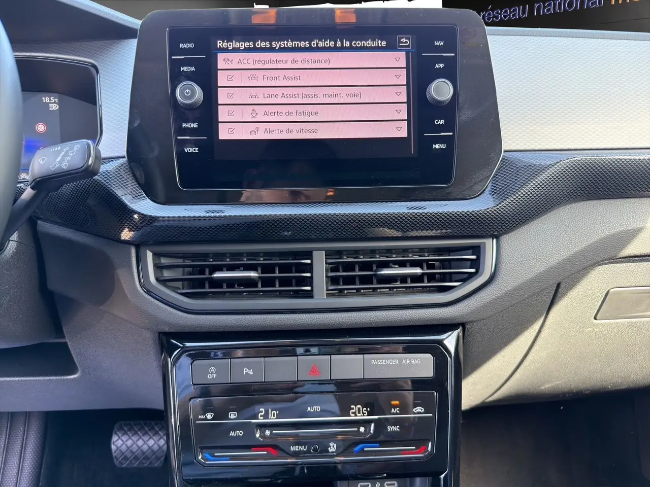 Vue rapprochée du tableau de bord noir du Volkswagen T-Cross 2025, écran tactile affichant les aides à la conduite.