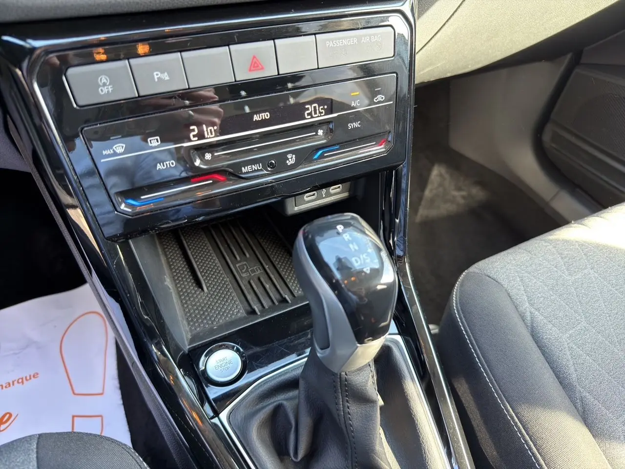 Vue rapprochée de la console centrale du Volkswagen T-Cross 2025, avec levier de vitesse DSG et climatisation tactile.