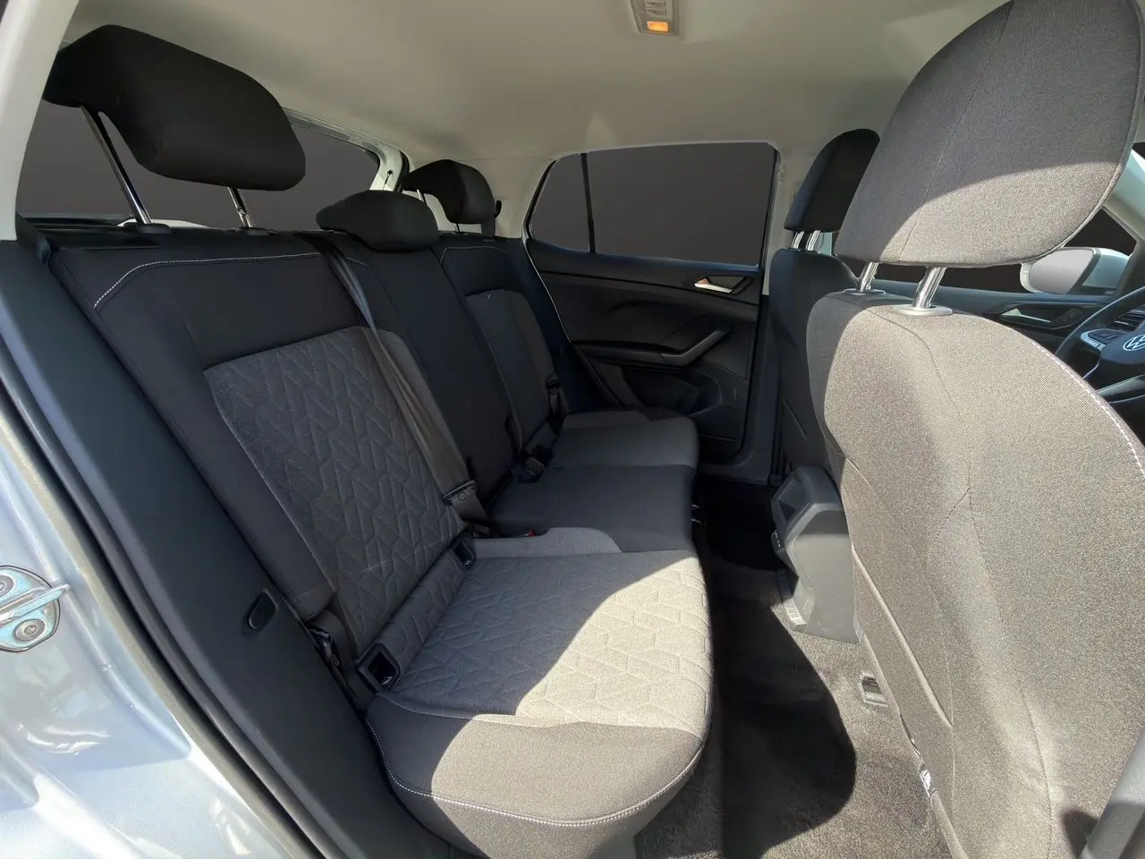 Vue intérieure côté gauche sur la banquette arrière tissu noir et gris du Volkswagen T-Cross reflet d'argent.