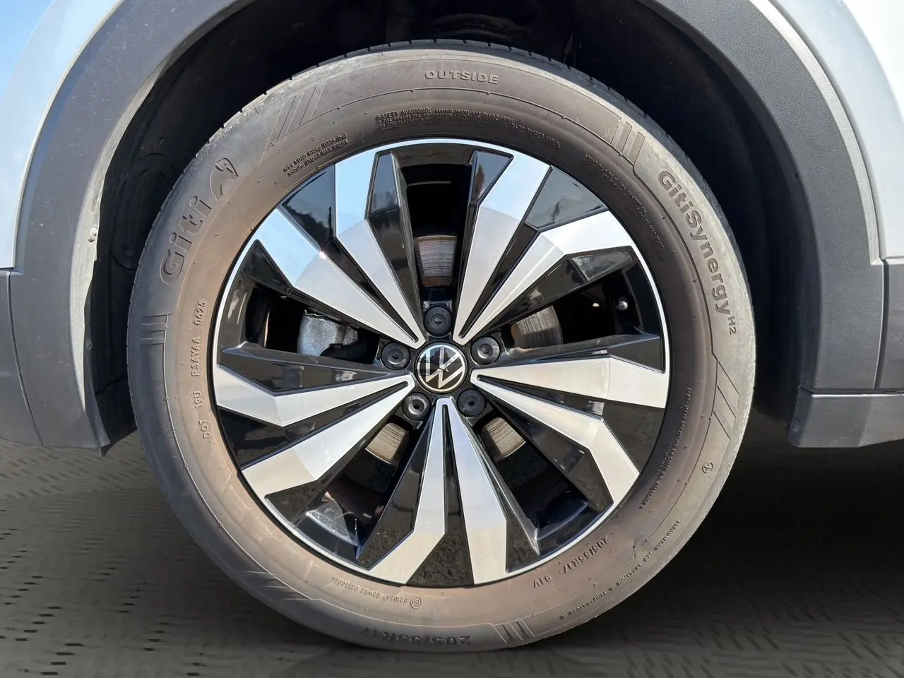 Gros plan sur la jante alliage 17 pouces bicolore du Volkswagen T-Cross reflet d'argent, avec pneu Giti Synergy.