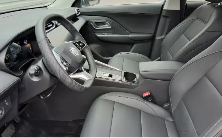 Vue intérieure côté conducteur du MG ZS 1.5 Hybrid+ 197 Luxury, sièges cuir noirs et tableau de bord moderne.