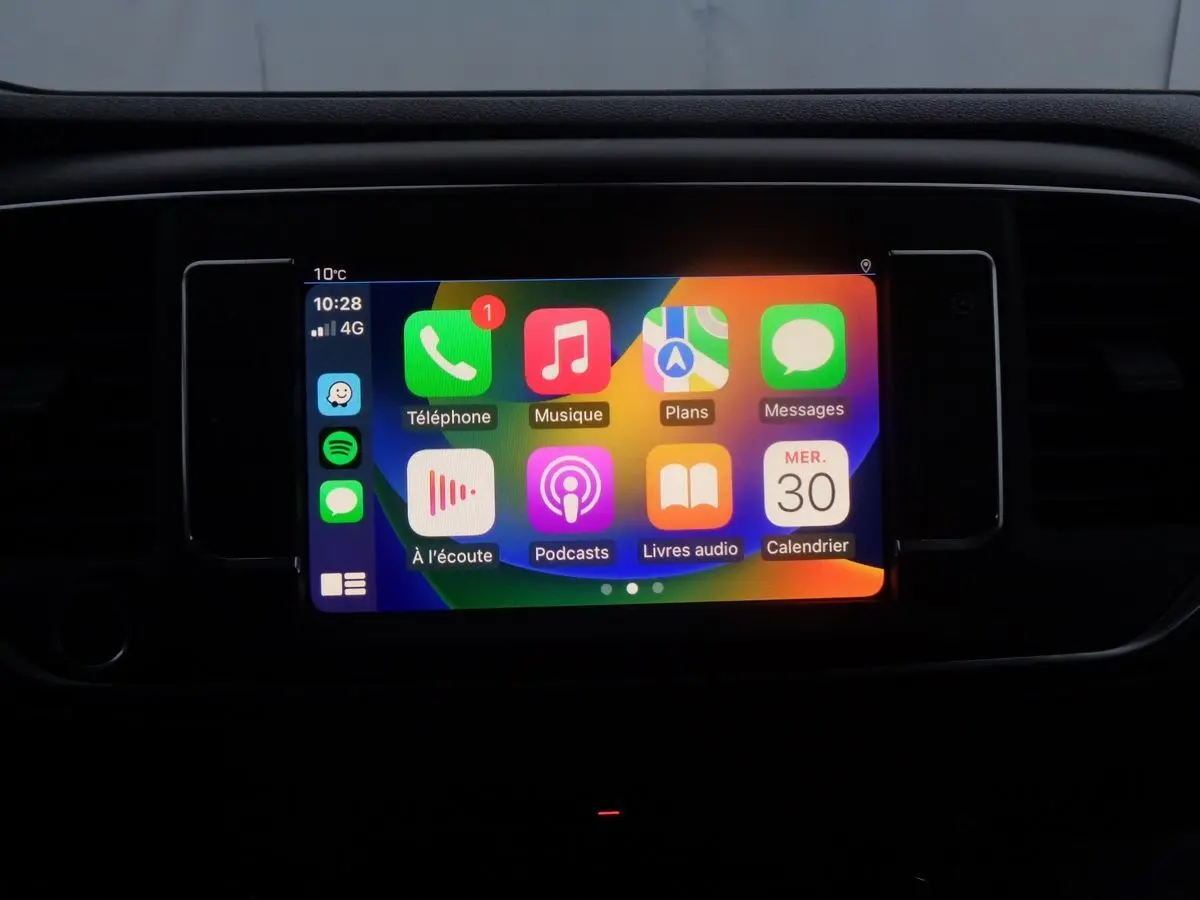 Écran tactile multimédia allumé dans l'habitacle du Peugeot Expert Fourgon noir, affichant les applications connectées.