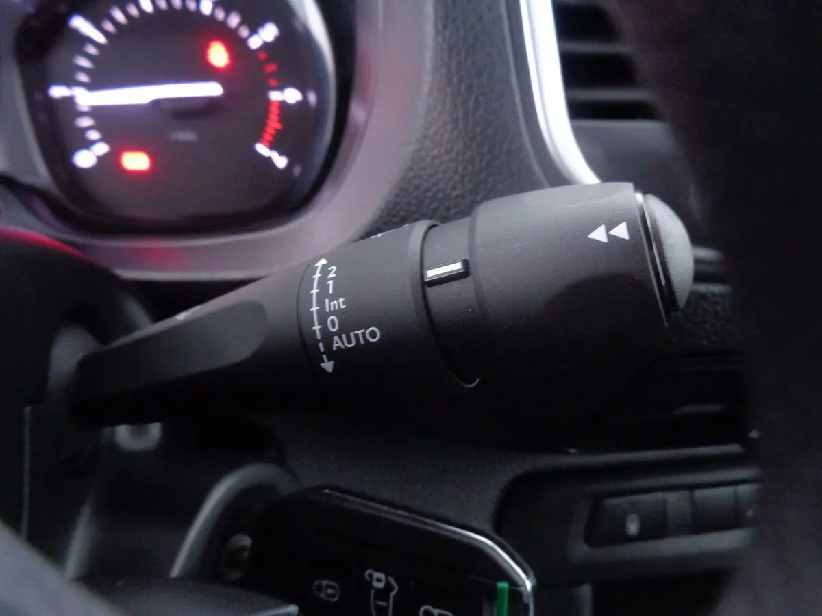 Gros plan sur la manette d'essuie-glace du Peugeot Expert Fourgon noir 2022, avec tableau de bord en arrière-plan flou.