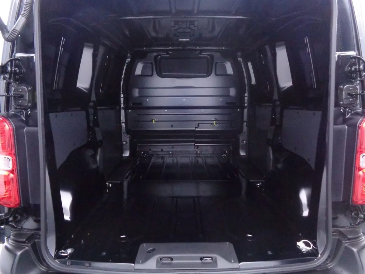 Vue intérieure arrière du Peugeot Expert Fourgon noir 2022, montrant l'espace de chargement vide et les parois métalliques.
