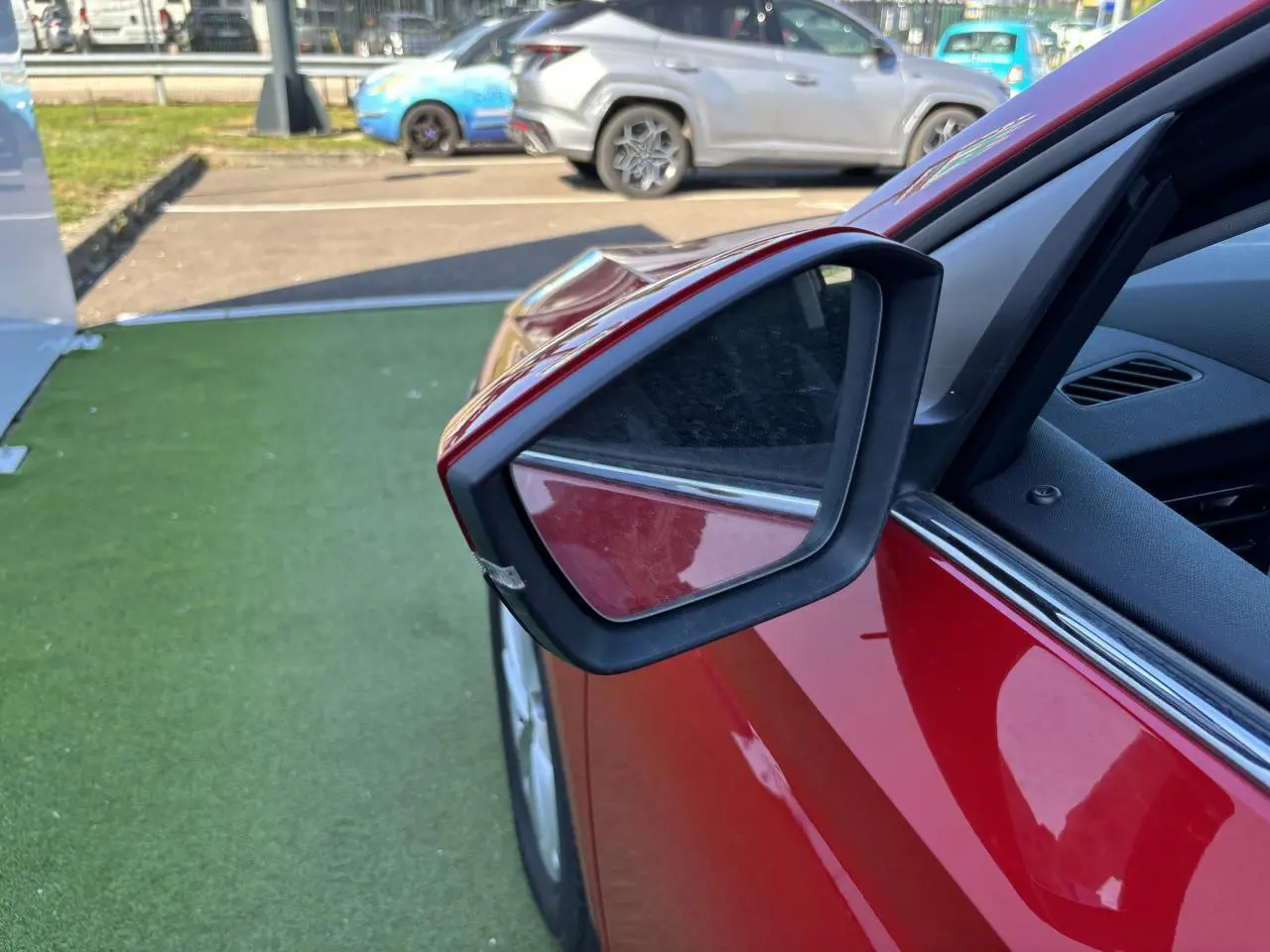 Rétroviseur extérieur côté gauche d'une Skoda Scala rouge Velvet Metal, avec partie de la portière visible.