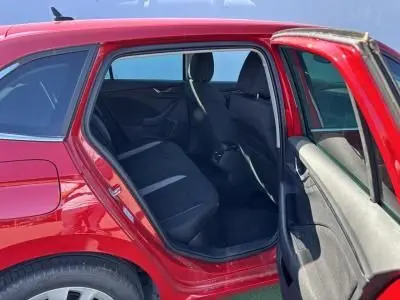 Intérieur arrière côté gauche d'une Skoda Scala rouge Velvet Metal avec porte ouverte et sièges noirs visibles