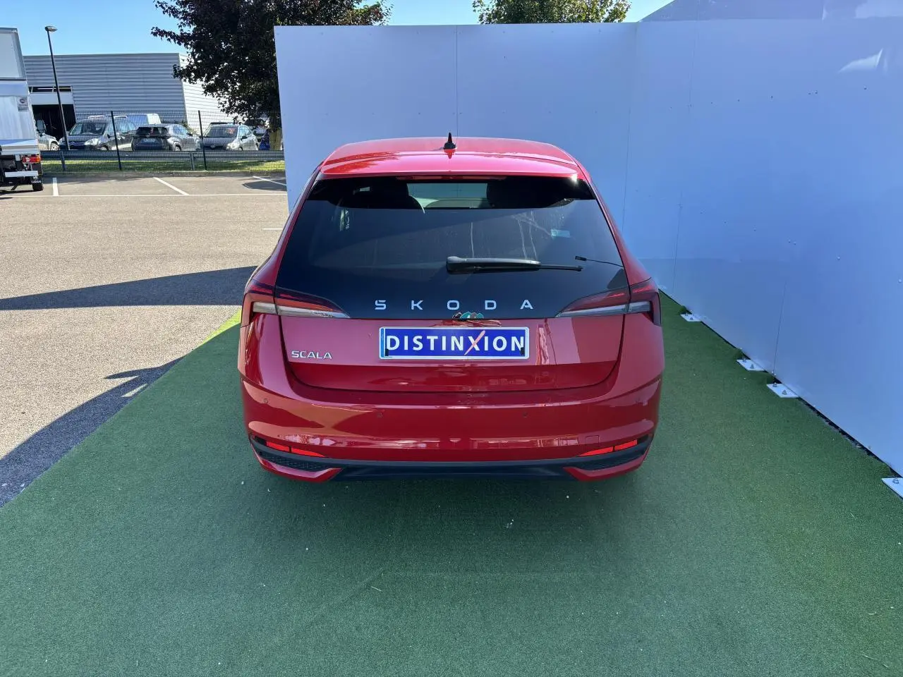 Vue arrière d'une Skoda Scala rouge Velvet Metal avec feux arrière Full LED et plaque Distinxion.
