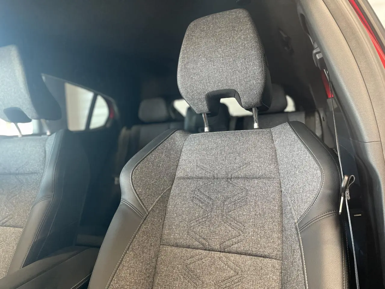 Gros plan sur le siège avant droit gris textile et cuir du Renault Rafale 2025 avec surpiqûres argentées.