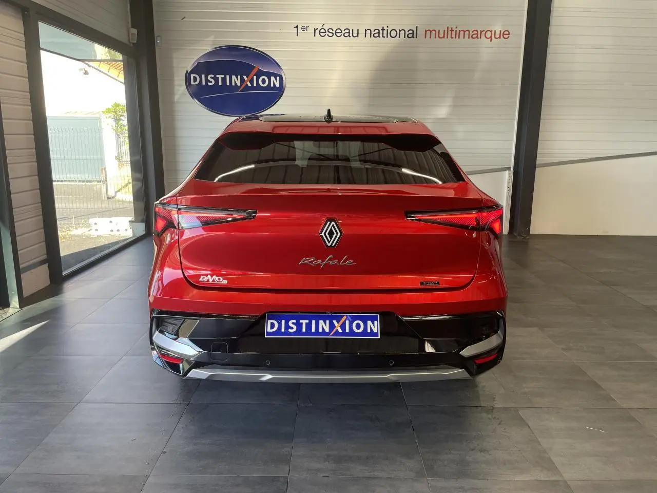 Vue arrière d'une Renault Rafale rouge à toit noir avec feux LED en forme de flèche et logo central brillant.