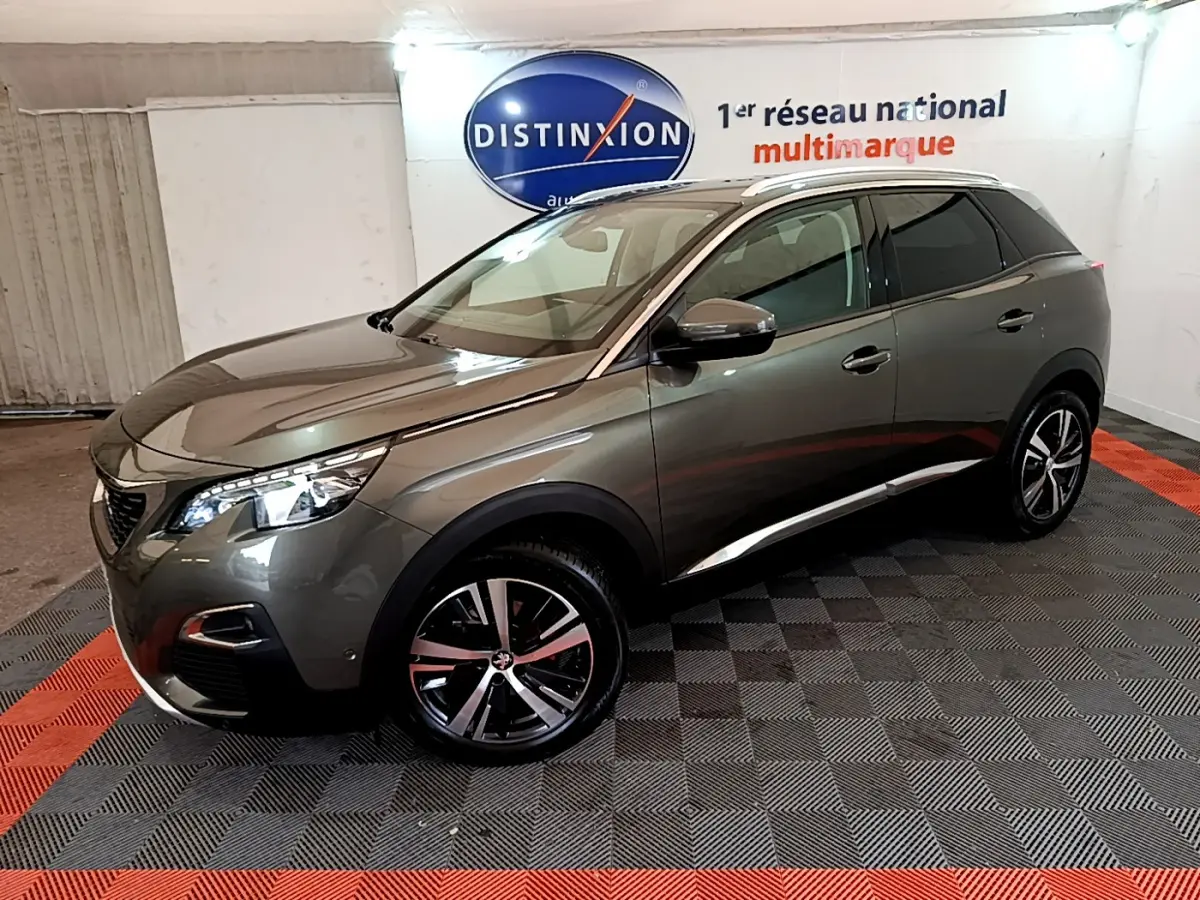 Peugeot 3008 gris clair en 3/4 avant droit, avec jantes alliage et toit panoramique en intérieur showroom.