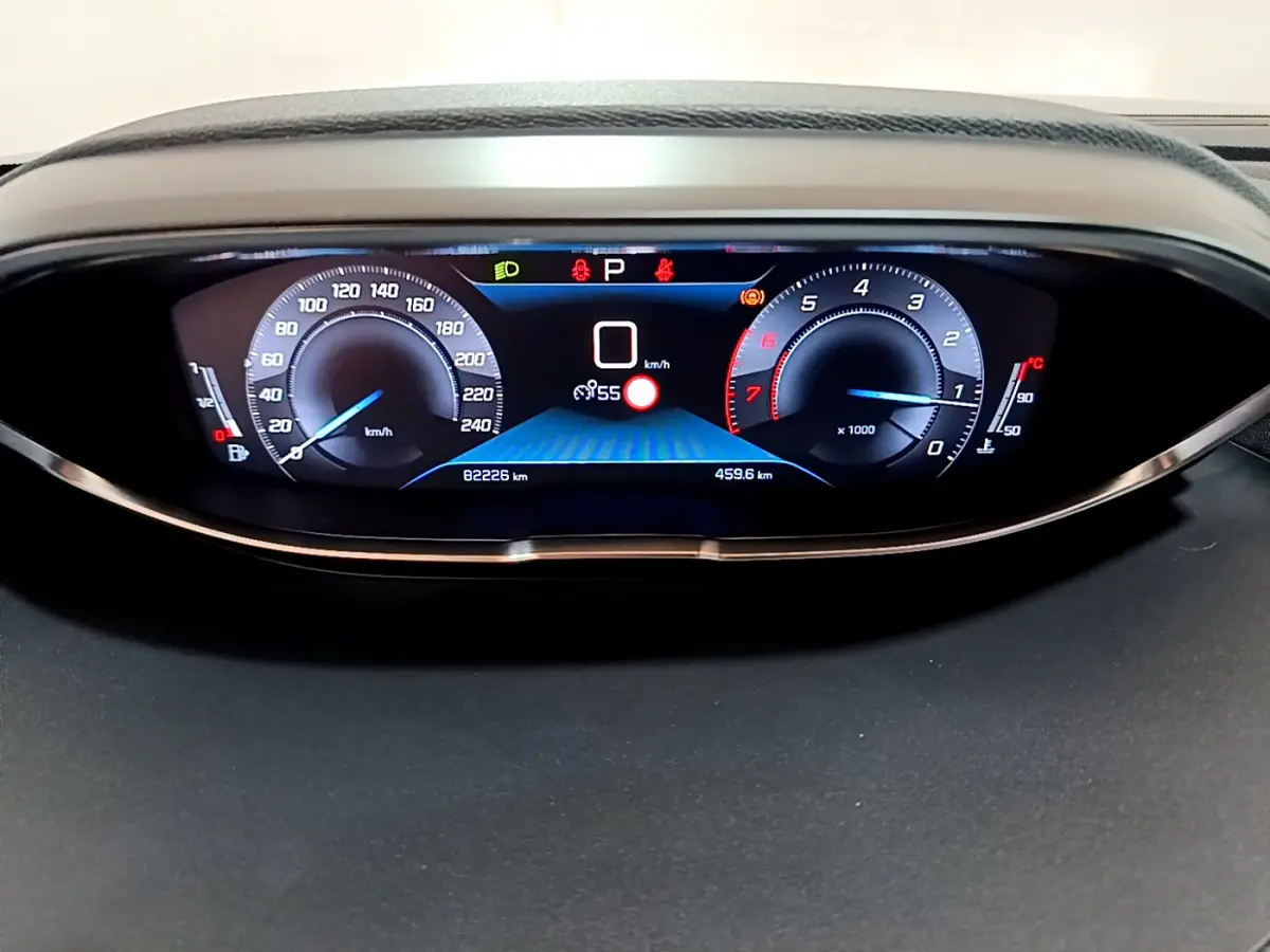 Tableau de bord numérique du Peugeot 3008 gris clair, affichage vitesse et compte-tours en vue frontale rapprochée.