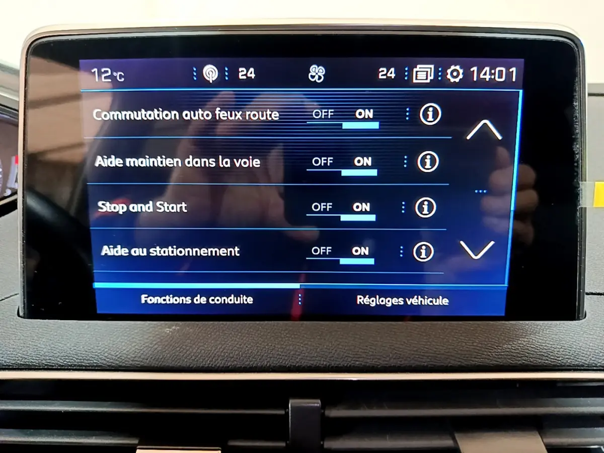 Écran tactile central du tableau de bord du Peugeot 3008 gris clair, affichant les aides à la conduite activées.