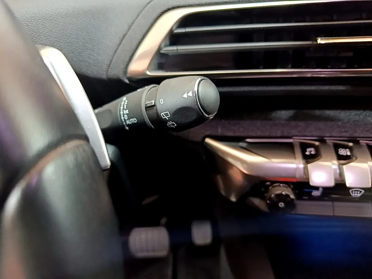 Gros plan sur la commande d’essuie-glace côté gauche du tableau de bord gris foncé du Peugeot 3008 gris clair 2020.