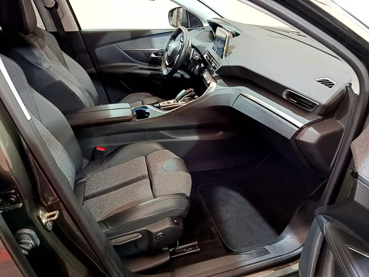 Intérieur avant droit du Peugeot 3008 gris clair 2020, avec sièges tissu-cuir et écran tactile central visible.