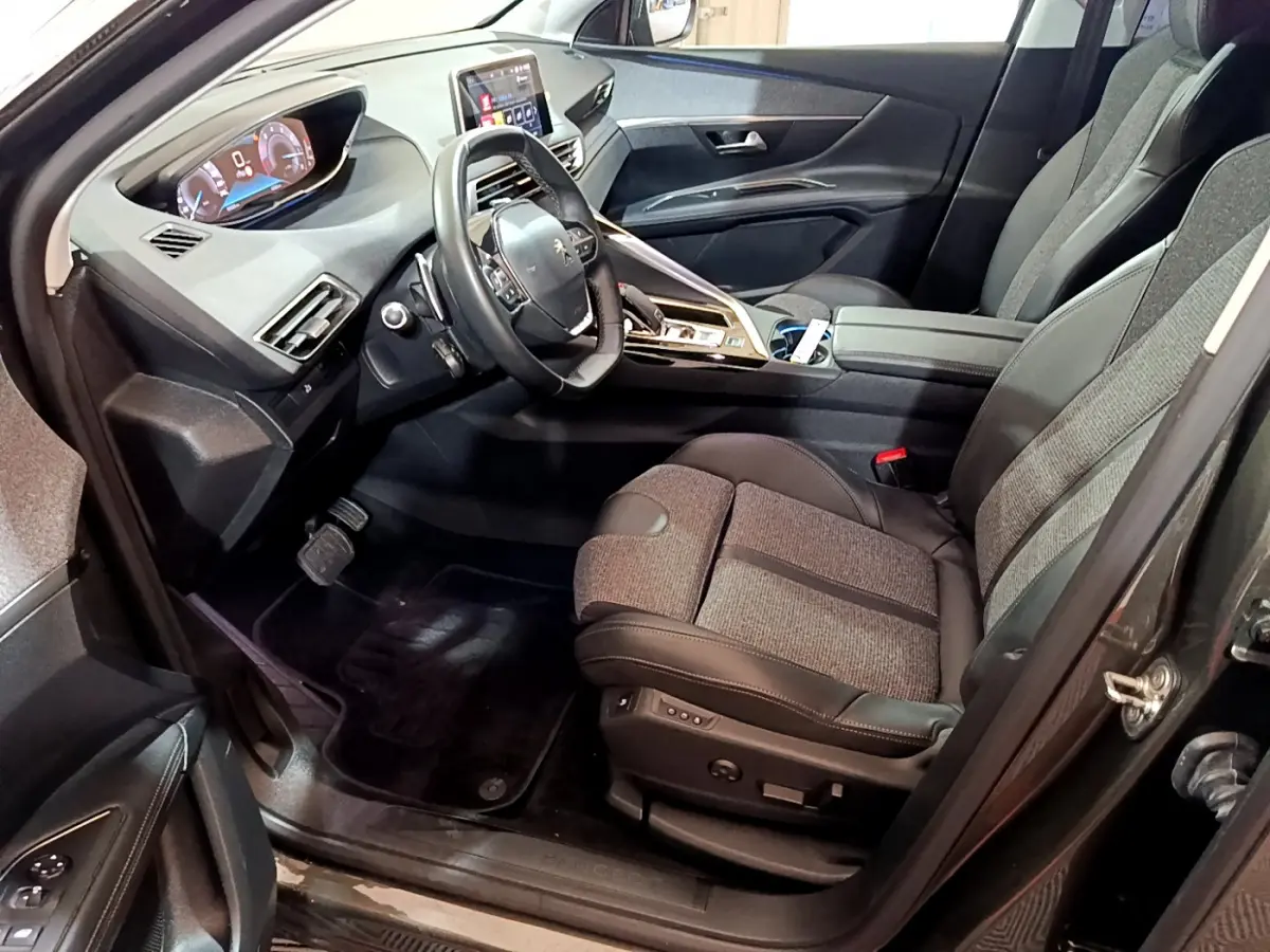 Intérieur avant droit du Peugeot 3008 gris clair 2020, avec tableau de bord digital et sièges tissu-cuir bicolores.
