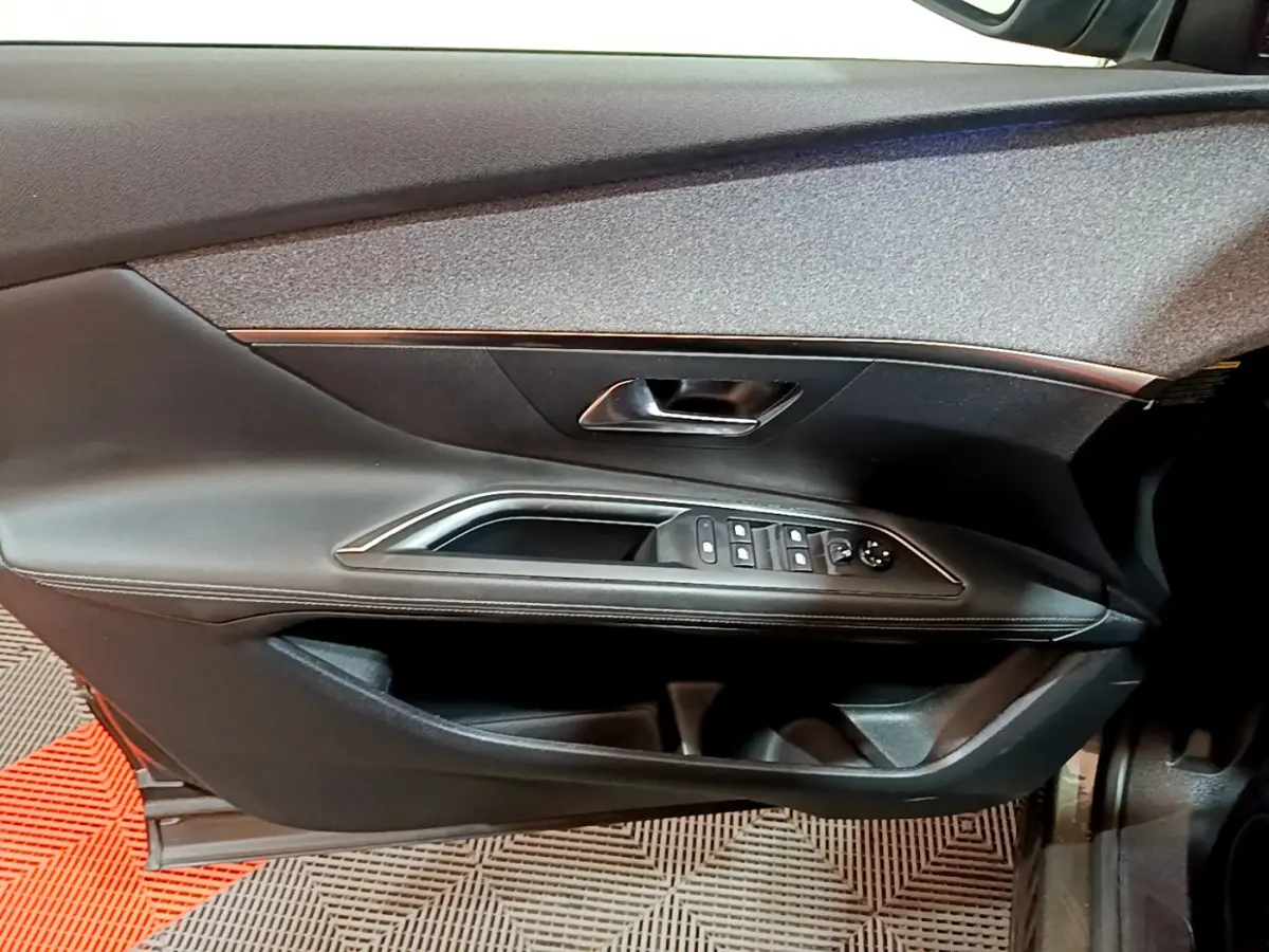 Vue rapprochée de la porte côté gauche du Peugeot 3008 gris clair, avec commandes de vitres et poignée intégrée.