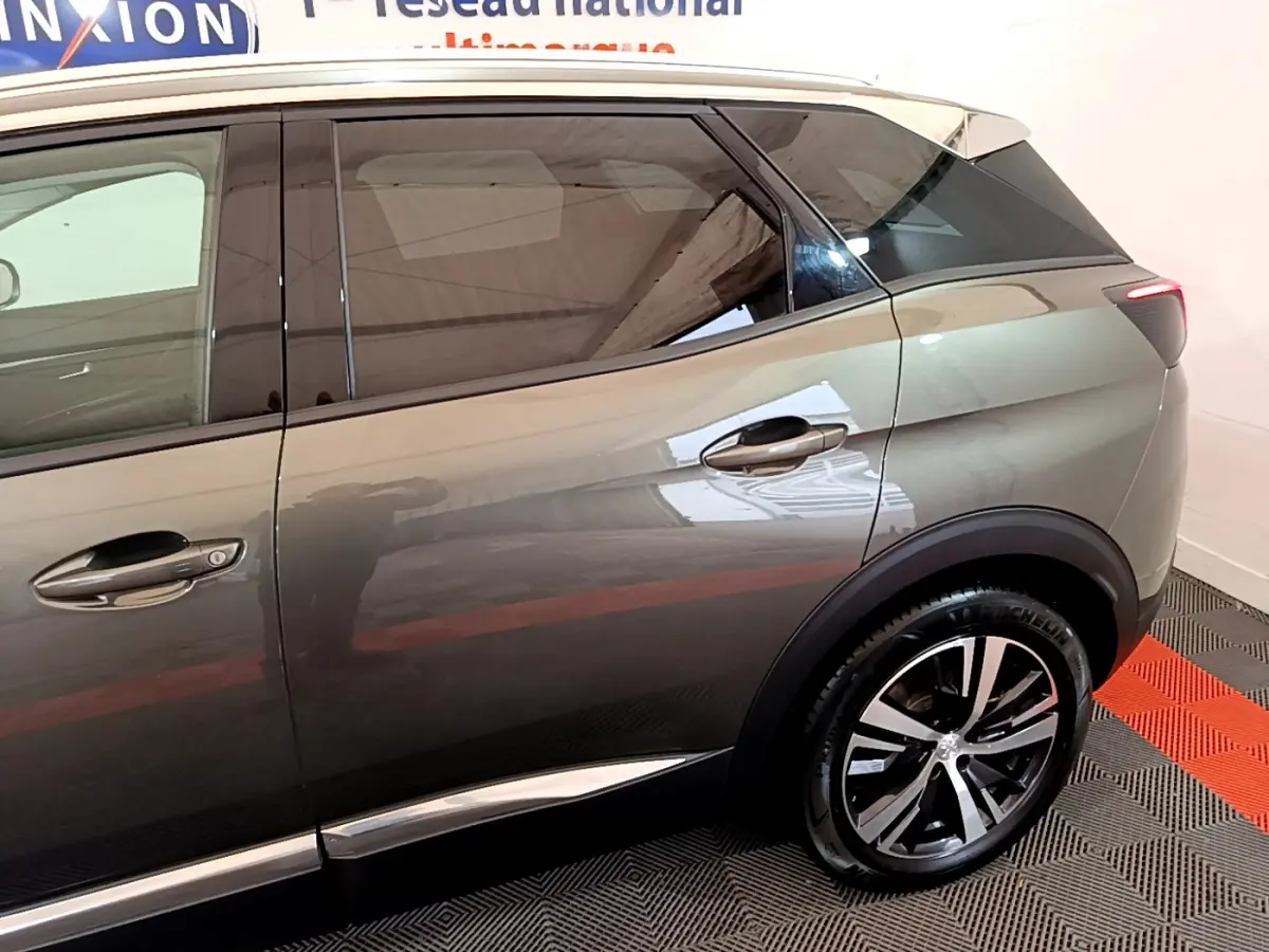 Vue latérale côté droit du Peugeot 3008 gris clair avec jante alliage et vitres teintées.
