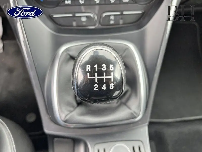 Gros plan sur le levier de vitesses manuel noir du Ford Kuga gris Magnetic de 2015, avec marquage des six rapports.