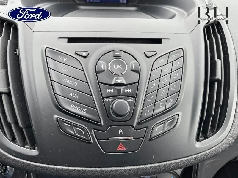 Vue rapprochée du tableau de bord noir du Ford Kuga 2015 avec commandes audio et climatisation intégrées.