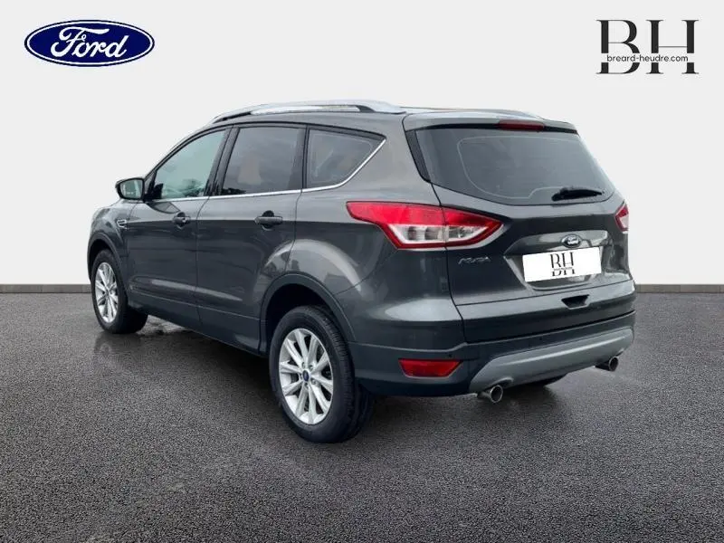 Vue 3/4 arrière droite d'un Ford Kuga gris Magnetic 2015 avec jantes alu et échappement double sortie.