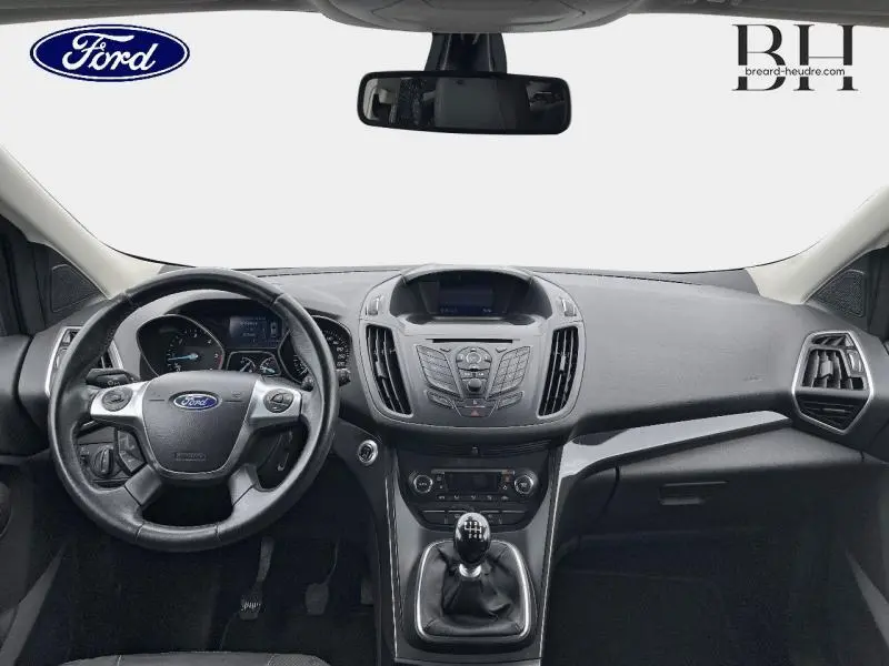 Vue intérieure avant du tableau de bord et volant cuir multifonction du Ford Kuga 2015 avec boîte manuelle.