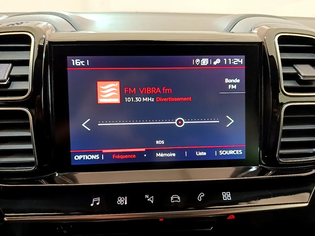 Écran tactile central affichant la radio FM dans l'habitacle noir du Citroën C5 Aircross, vue frontale rapprochée.