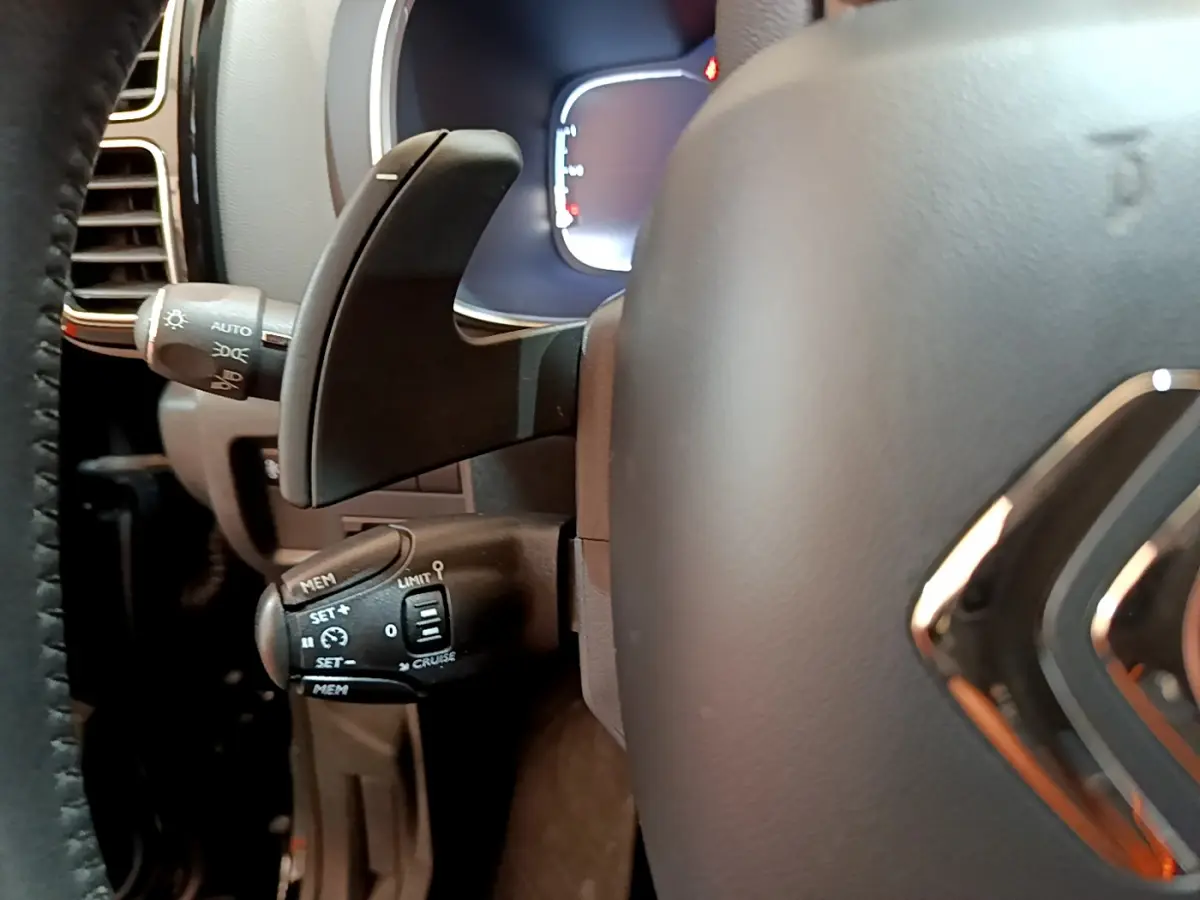 Gros plan sur la commande de régulateur de vitesse à gauche du volant cuir noir du Citroën C5 Aircross 2020.