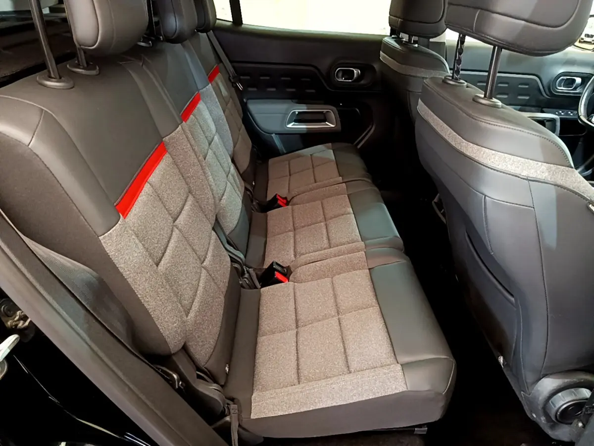 Vue intérieure côté gauche des sièges arrière gris et noir avec bande rouge du Citroën C5 Aircross noir de 2020.